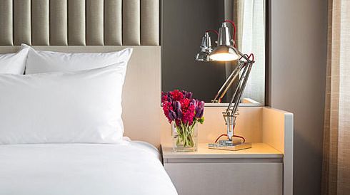 Fresh flowers rest on a nightstand at 21c Museum Hotel in Durham, NC.