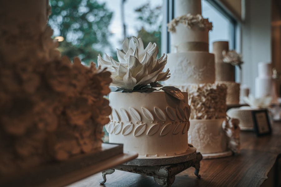 Beautifully crafted white cakes sit in a line at Mad Hatter Cafe and Bakeshop in Durham, NC.