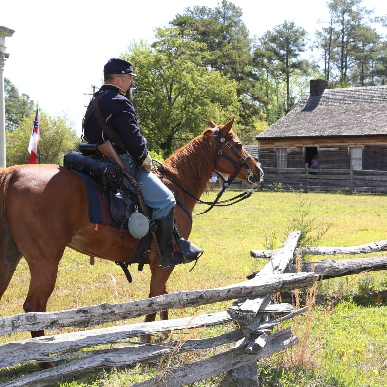 A Civil War reenactor speaks with a visitor at Bennett Place