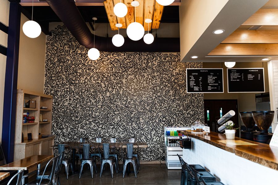 The tasteful lighting at People's Coffee illuminates the modern but grounded design of its seating area and front counter.