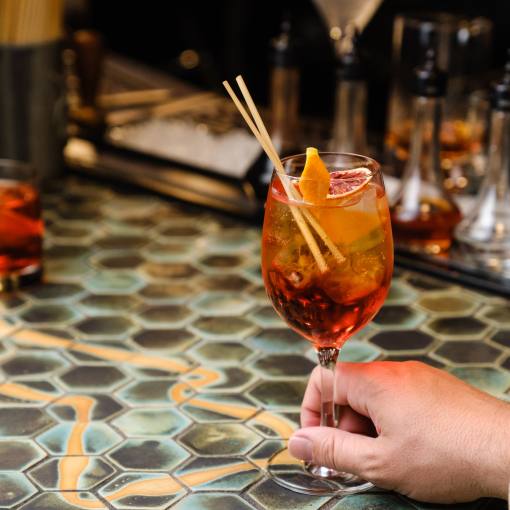 A customer holds a drink to the table at Kingfisher in Durham, NC.