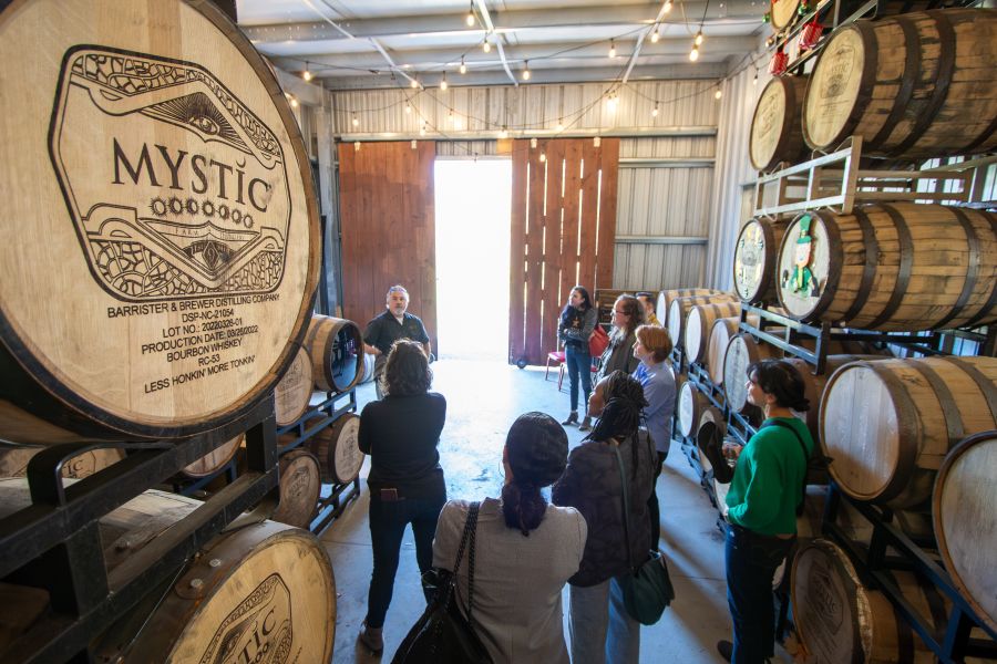 A tour guide speaks with a group at Mystic Farm Distillery.