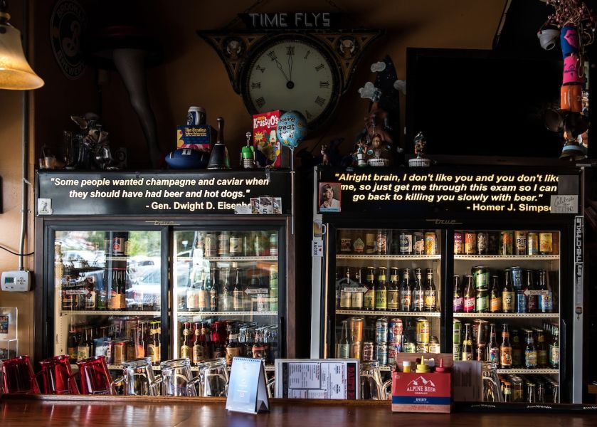Dim lights expose the cooler behind the bar at Dain's Place in Durham, NC.