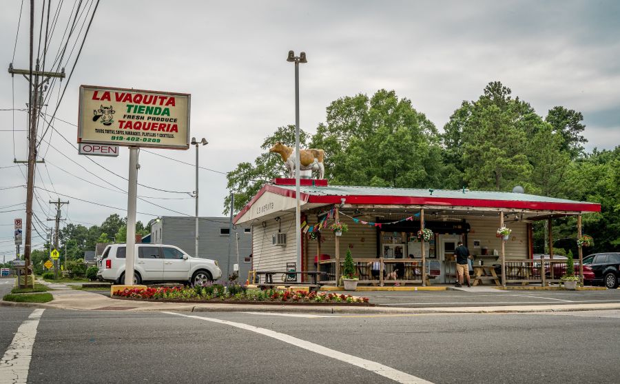 The sign for Taqueria La Vaquita stands tall over its outdoor patio.