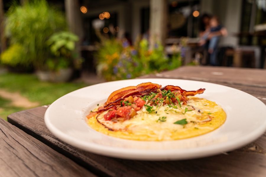 A bacon and grits bowl from ﻿Foster's Market in Durham foregrounds the storefront.
