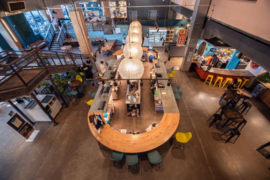 An areal view of The Durham Food Hall shows customers purchasing food and dining.