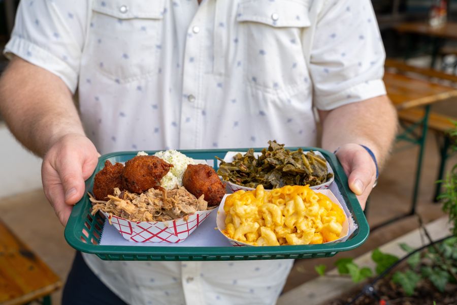 Wyatt Dickson holds a pulled pork barbecue plate at Picnic. Wyatt is the owner and pitmaster of Picnic.