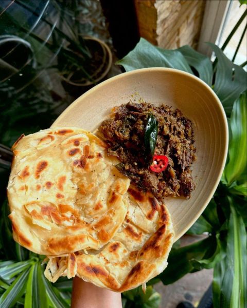 A bowl Kerala Pepper Beef & Malabar Parathas (flat bread) at Cheeni in Durham, NC.