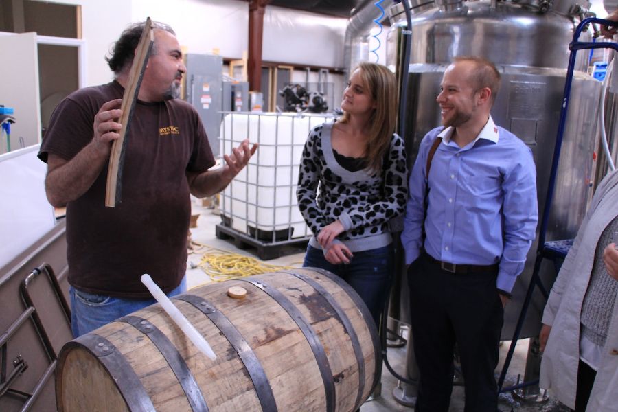 A couple enjoy a behind-the-scenes tour at Mystic Farm & Distillery.