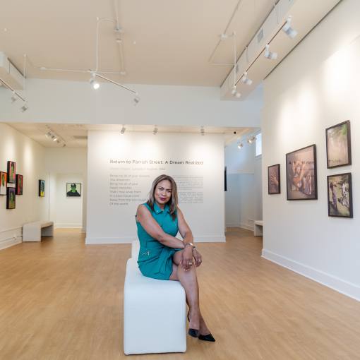 The owner of Ella West Gallery, Linda Shopshire, sits in the middle of the main gallery room.