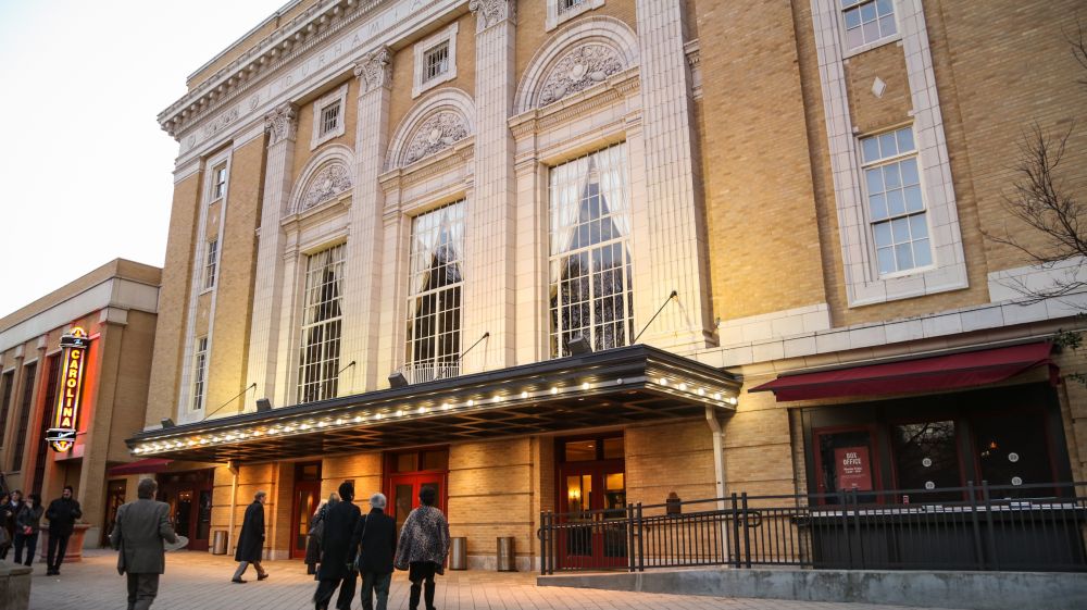 Visitors walk in front of the Carolina Theatre in downtown Durham.