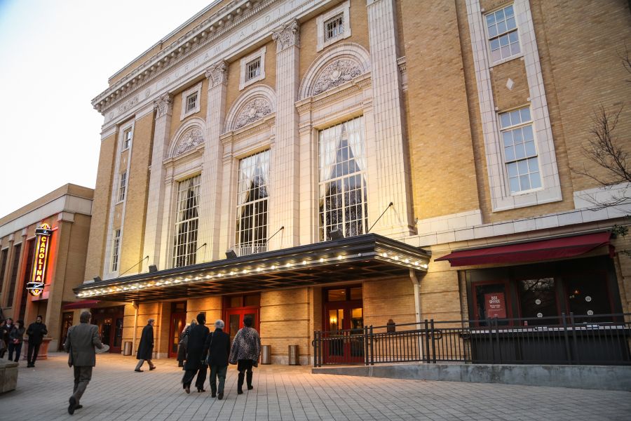 Visitors walk in front of the Carolina Theatre in downtown Durham.