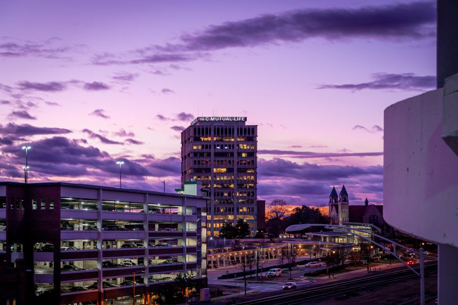 The NC Mutual Life building stands tall and lit up at sunset in Durham, NC.
