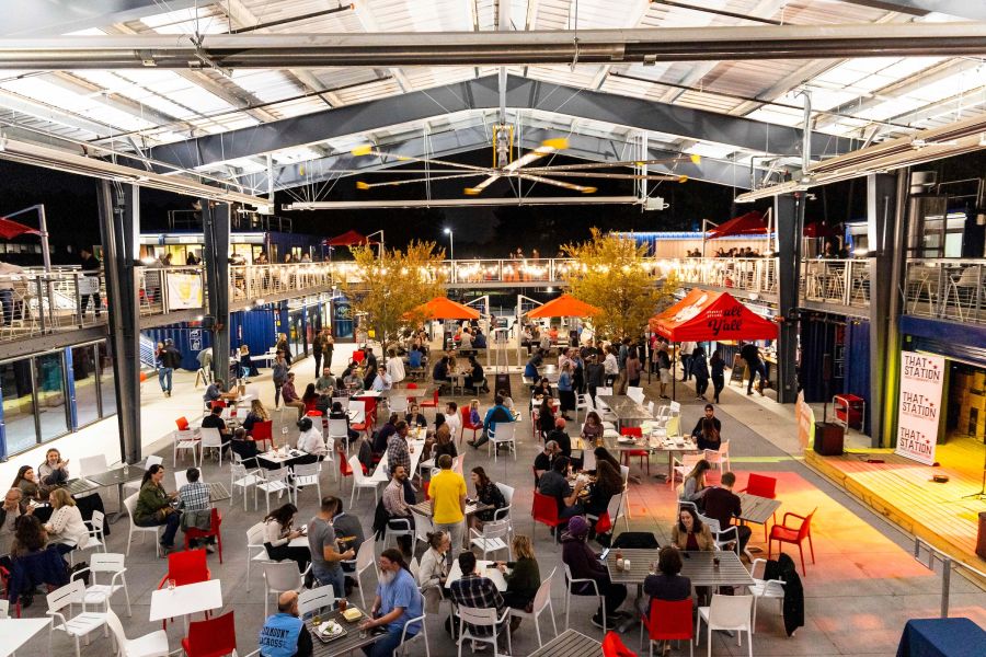 Customers sit and socialize as they eat and drink under the pavilion at Boxyard RTP.