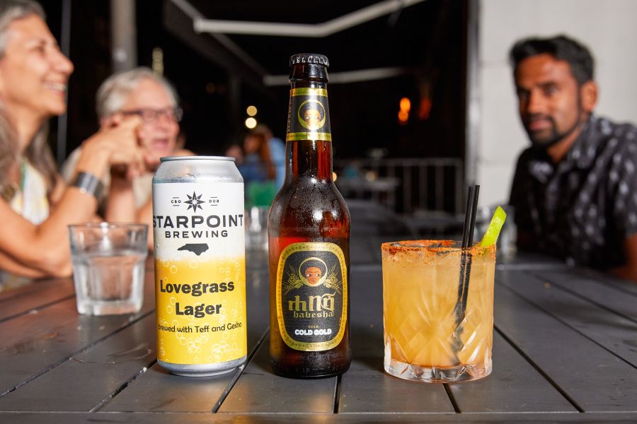 Customers sit and chat at a table with a Starpoint Brewing beer centered on the table.