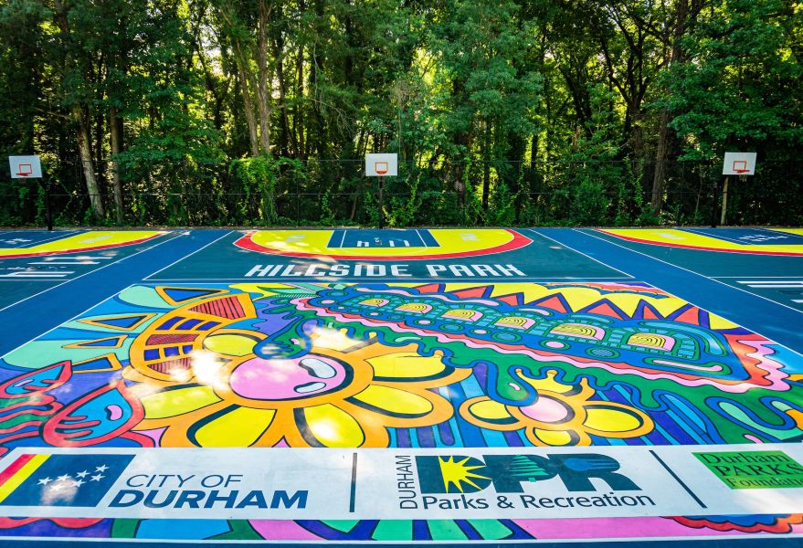 Colorful mural-style artwork adorns the ground at Hillside Park Basketball Courts.