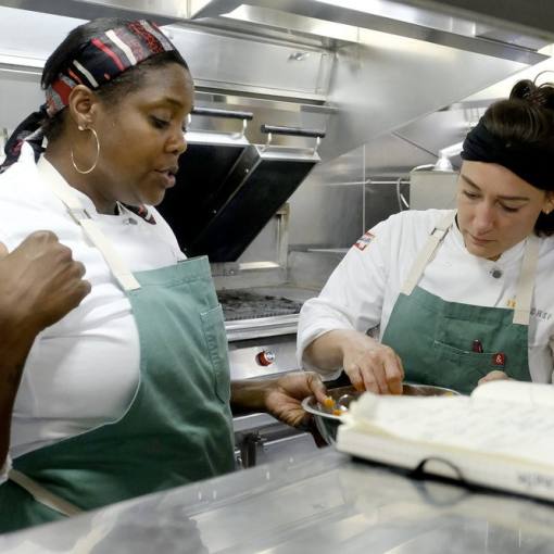 Durham Chef Savannah Miller talks with a person in the kitchen on the set of Top Chef Season 21.