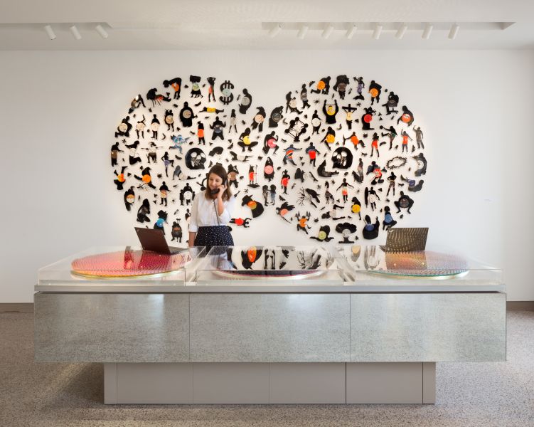 A woman on the phone stands behind the front desk of 21c Museum Hotel.