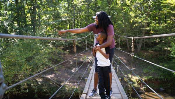 A mother and child view nature on the suspension bridge at Eno River State Park.