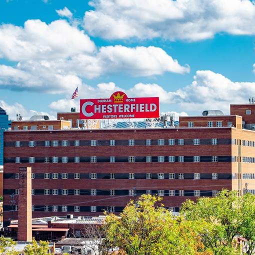Downtown Durham skyline with the Chesterfield's red "Visitors Welcome" sign prominent in the foreground
