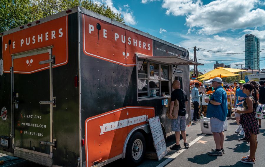 Customers line up at the Pie Pushers food truck waiting for pizza.