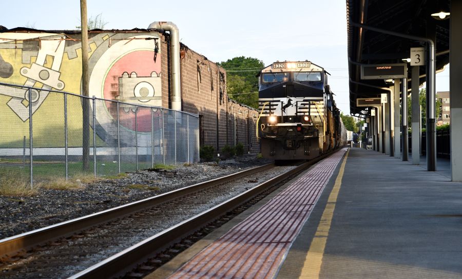 A train passes through the Durham Amtrak station on a sunny day.