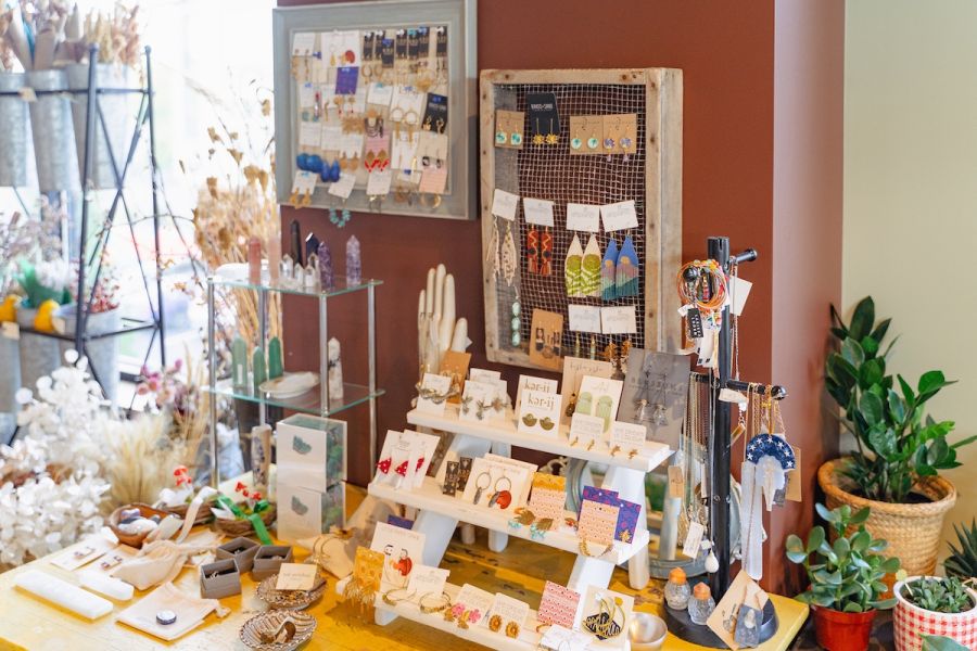 A table at Bowerbird Flowers and Apothecary in UHills is set with cards, flowers, and trinkets.