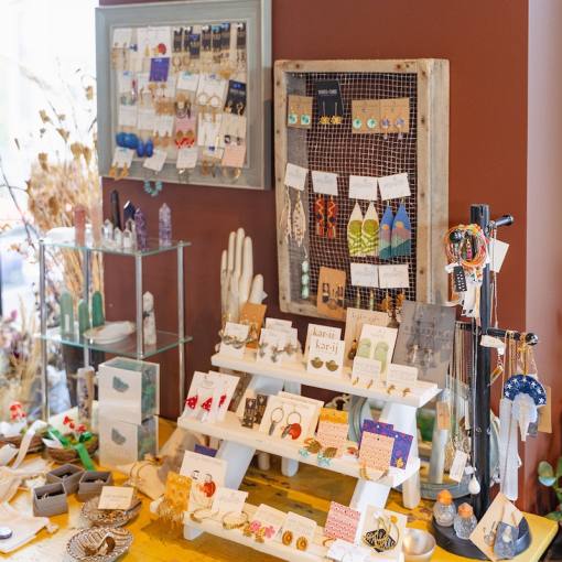 A table at Bowerbird Flowers and Apothecary in UHills is set with cards, flowers, and trinkets.